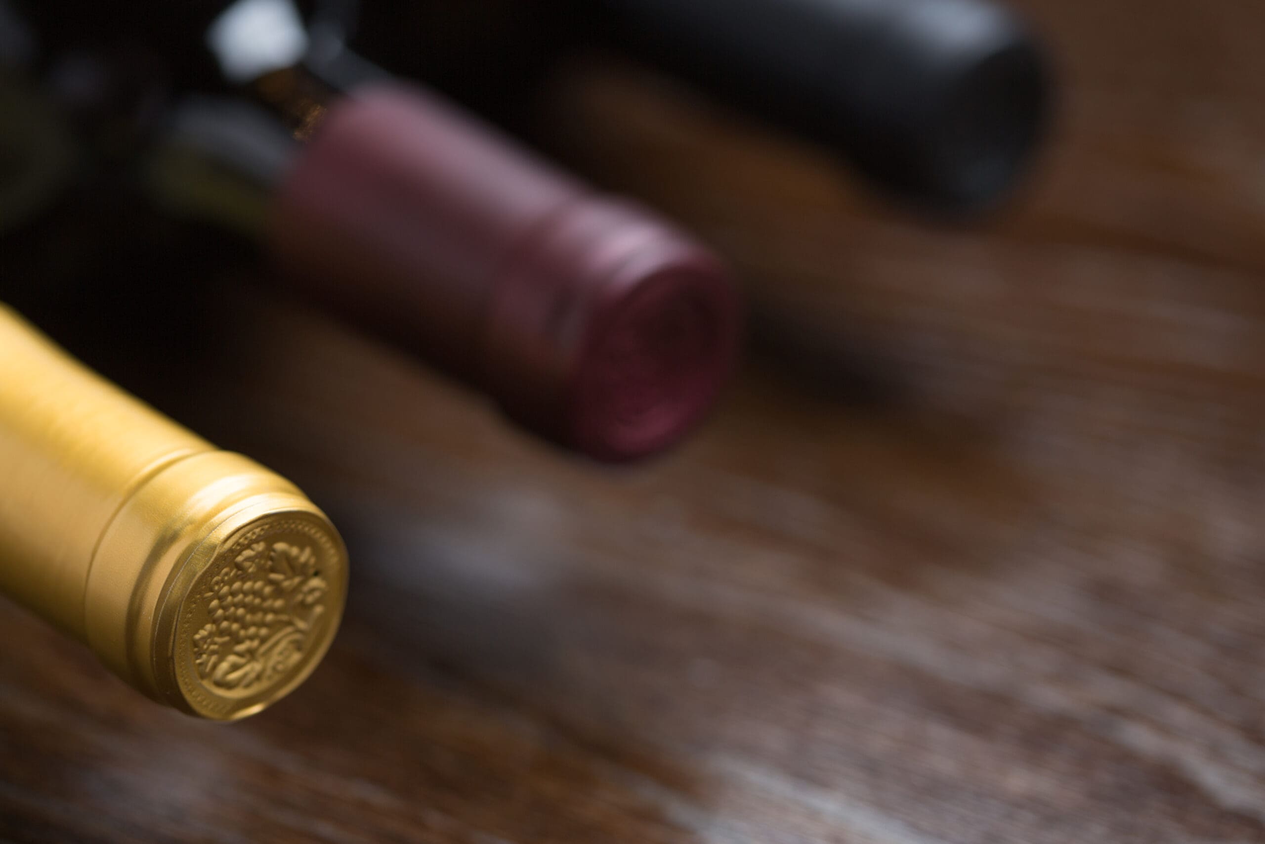 Various wine bottles arranged on a reflective wooden surface